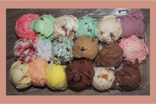 A colorful assortment of ice cream scoops in various flavors arranged in a tray.