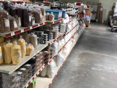 A grocery store aisle filled with various bags of grains, flours, and other dry goods on shelves.