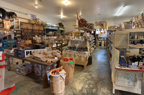 A cozy store interior filled with shelves of goods, baked items, and rustic decor, creating a warm shopping atmosphere.