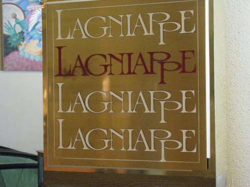 Sign featuring the word "Lagniappe" repeated in various styles and colors.