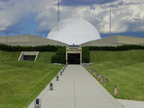 Pathway leading to the Armstrong Air and Space Museum, with flags lining the sides and a large dome in the background.
