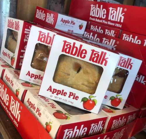 A display of Table Talk apple pie boxes stacked together, featuring red packaging with apple graphics.