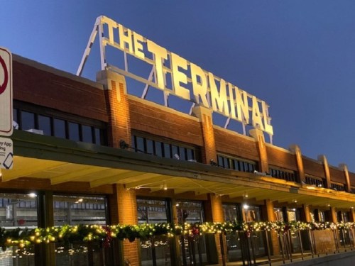 The Terminal building illuminated at dusk, adorned with festive lights and greenery along the entrance.
