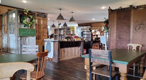 Cozy café interior with wooden tables, a rustic counter, and festive decorations. Warm and inviting atmosphere.