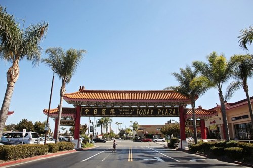A vibrant entrance to Today Plaza featuring a traditional archway and palm trees under a clear blue sky.