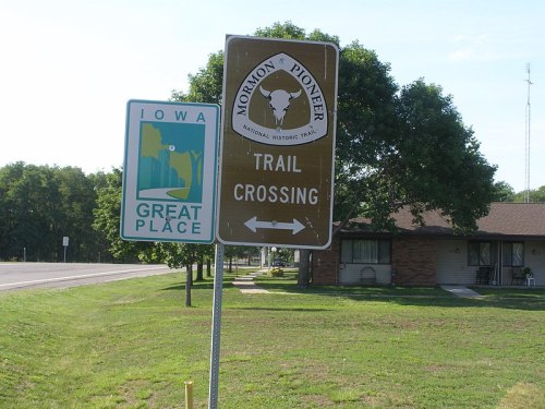 Signage for the Mormon Pioneer National Historic Trail crossing, with an Iowa Great Place sign nearby.