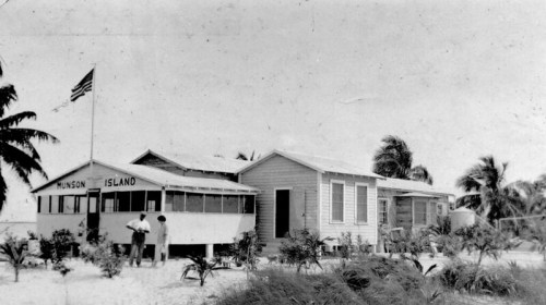 Black and white photo of a building labeled "Munson Island," surrounded by palm trees and sandy terrain.