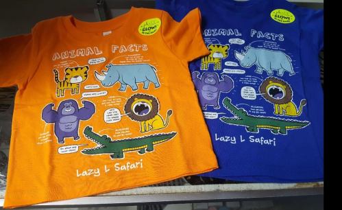 Two colorful t-shirts, one orange and one blue, featuring cartoon animals and fun facts about them.