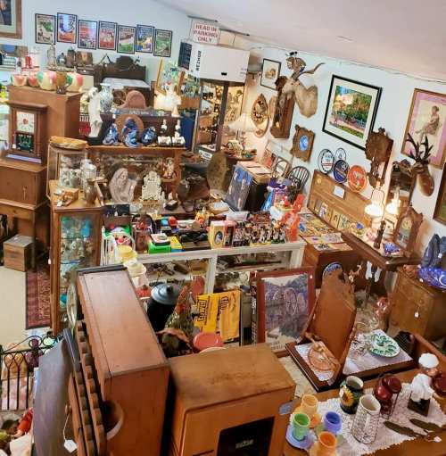 A cozy antique shop filled with various vintage items, including furniture, decor, and collectibles.