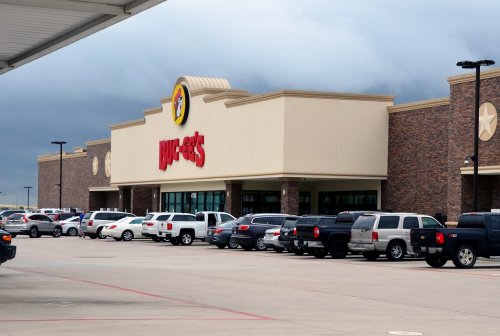 A large Buc-ee's store with a parking lot filled with various vehicles under a cloudy sky.
