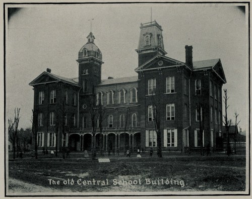 Historic black-and-white photo of the old Central School Building, featuring a large brick structure with a tower.