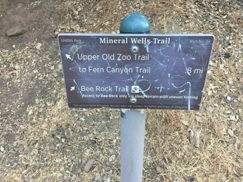 Signpost at Griffith Park indicating directions to Upper Old Zoo Trail and Bee Rock Trail, with distance noted.