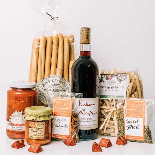 A selection of Italian food items including pasta, sauce, wine, snacks, and spices arranged on a white background.