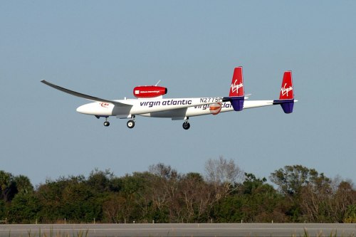 A Virgin Atlantic aircraft in flight, showcasing its distinctive red and white livery against a clear blue sky.