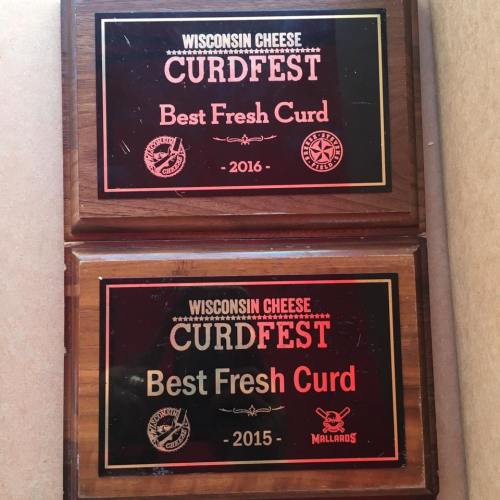 Two wooden plaques for "Best Fresh Curd" from Wisconsin Cheese Curdfest, dated 2015 and 2016.