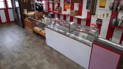 Interior of an ice cream shop featuring a service counter, display cases, and colorful decor.