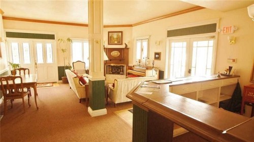 Cozy interior of a living room with a fireplace, seating area, and dining table, featuring warm lighting and inviting decor.