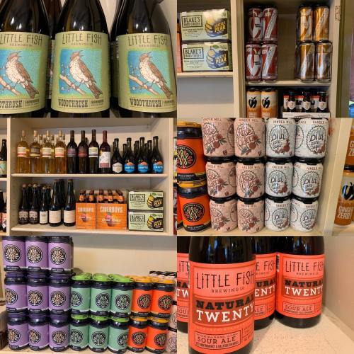 A variety of craft beverages displayed on shelves, including beers, ciders, and spirits from different brands.