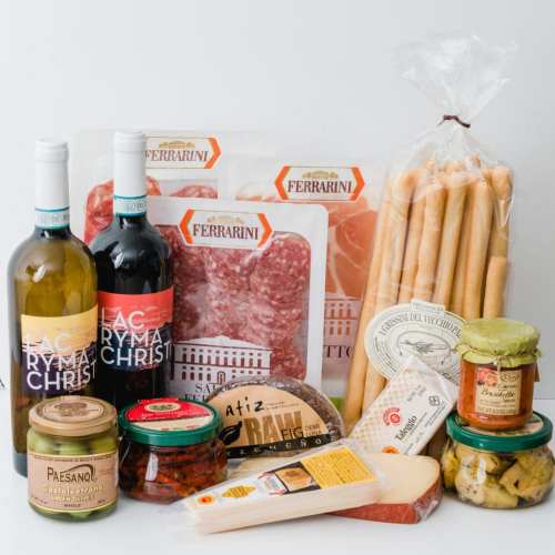 A selection of Italian gourmet foods, including wine, cured meats, breadsticks, and various jars of condiments.