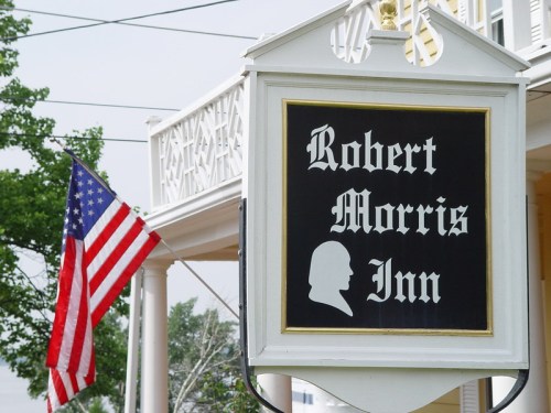Sign for Robert Morris Inn with a silhouette and an American flag in the background.
