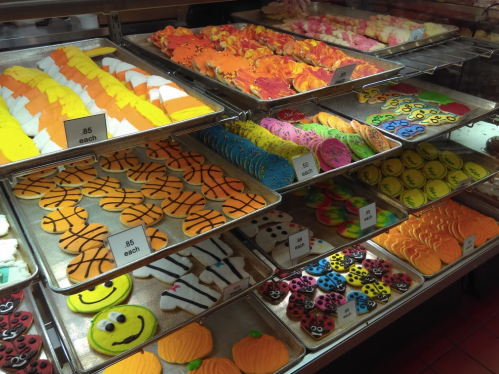 A display of colorful, decorated cookies in various shapes, including sports, animals, and seasonal themes.