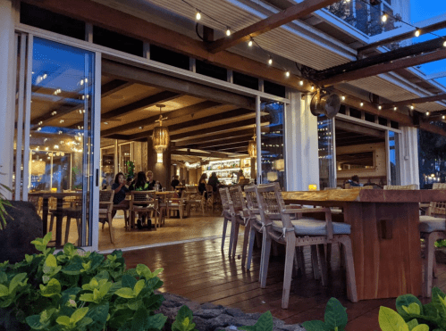 A cozy restaurant with wooden furniture, warm lighting, and patrons enjoying their meals in a relaxed atmosphere.