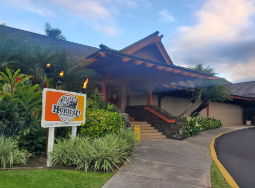 Exterior of Hukilau Lanai restaurant, featuring tropical landscaping and a welcoming entrance.