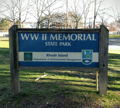 Sign for WWII Memorial State Park in Rhode Island, featuring the state seal and Department of Environmental Management logo.