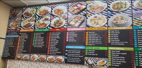 Menu board featuring various Asian dishes, including sushi, noodles, and family platters, with prices listed.