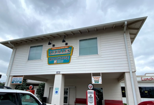 Exterior of Lucille's Roadhouse, a two-story building with a sign, under a cloudy sky.
