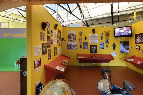Colorful exhibit featuring masks, artifacts, and informational displays about different cultures and traditions.