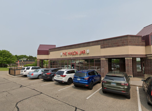 Exterior view of "The Mason Jar" restaurant with parked cars in front and a clear blue sky.
