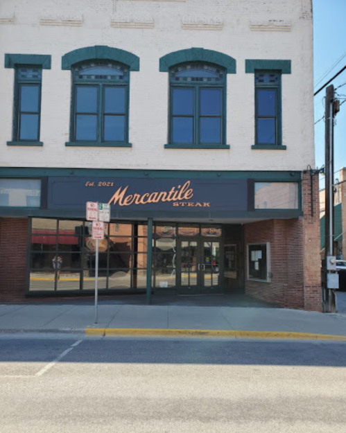 Exterior of Mercantile Steak restaurant, featuring large windows and a sign with "Est. 2021" above the entrance.