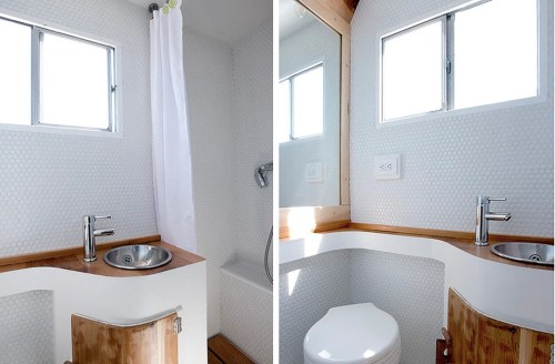Bright, modern bathroom featuring a shower, sink with wooden accents, and a toilet, all in a minimalist design.