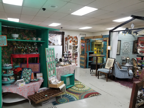 A vibrant antique shop interior featuring colorful displays, vintage furniture, and decorative items for sale.