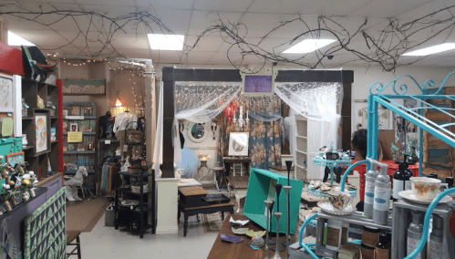 A cozy vintage shop interior with eclectic decor, bookshelves, and decorative lighting.