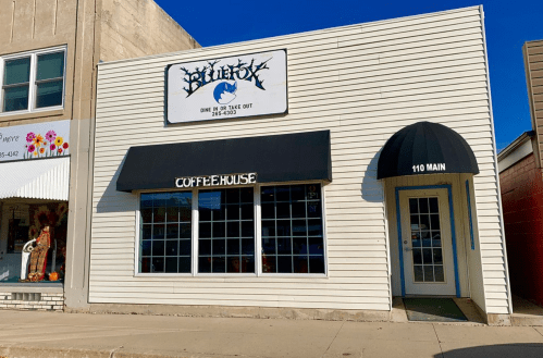 Exterior of a white building with a sign for "Blue Fox" and a black awning labeled "Coffeehouse" at 110 Main.