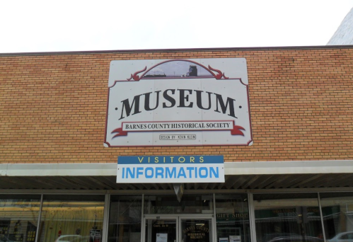 Sign for the Barnes County Historical Society Museum, featuring "MUSEUM" and "VISITORS INFORMATION" below.