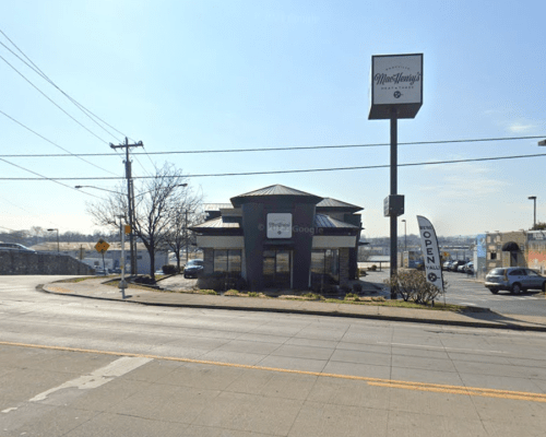 A restaurant building with a sign reading "Moe's Lounge," located at a street intersection on a sunny day.