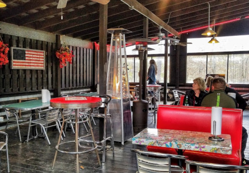 Cozy indoor dining area with red and silver furniture, a heater, and an American flag on the wall.