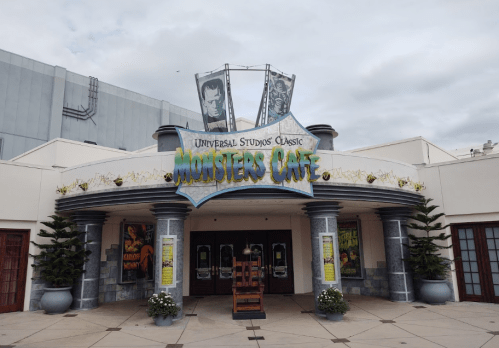 Entrance to Universal Studios' Monsters Cafe, featuring a colorful sign and movie posters on display.