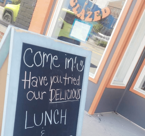 A chalkboard sign outside a restaurant invites customers to try their delicious lunch.