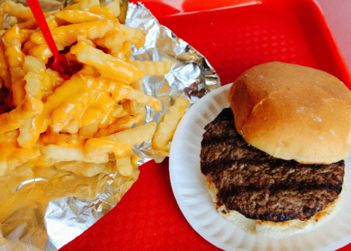 A plate with a cheeseburger on a bun and a serving of cheesy fries in foil.