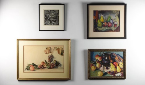 Four framed paintings on a wall, featuring still life compositions with fruits and flowers in various styles.