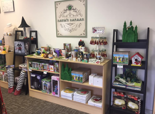 A cozy shop display featuring various crafts, toys, and decorative items on shelves and tables.