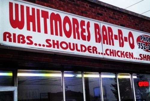 Sign for Whitmores Bar-B-Q featuring menu items: ribs, shoulder, chicken, and shrimp. Open for business.