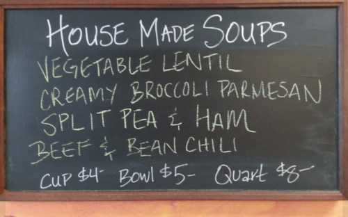 Chalkboard menu listing house-made soups: Vegetable Lentil, Creamy Broccoli Parmesan, Split Pea & Ham, Beef & Bean Chili. Prices included.