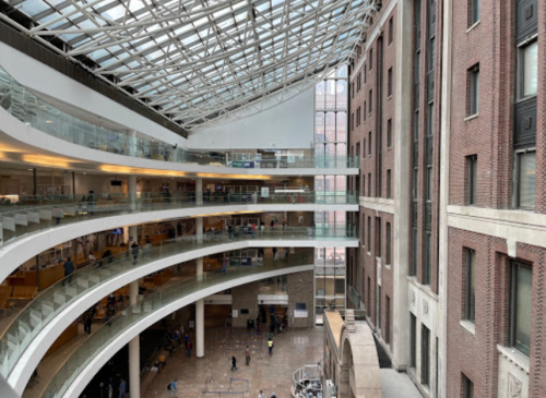 A modern atrium with glass ceilings, curved balconies, and a mix of brick and contemporary architecture.