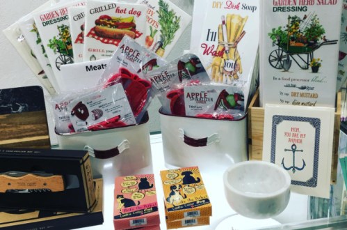 A display of various kitchen and cooking items, including dressings, soup mixes, and utensils in decorative packaging.