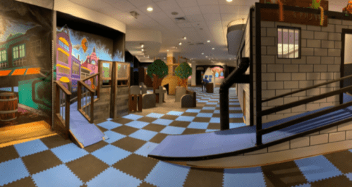 Colorful indoor play area with ramps, murals, and soft flooring, designed for children's activities and exploration.